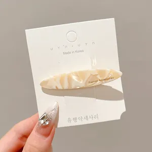 Elegant cream marble acrylic hair clip displayed on a white Korean brand card