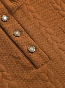 Close-up detail of jacquard texture and metallic buttons on brown men's Henley shirt