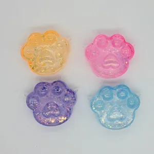 Vue détaillée de quatre jouets antistress en forme de patte de chat pailletée.