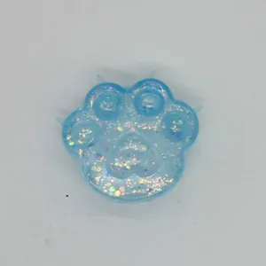 Vue en gros plan d'un jouet squishy patte de chat bleu clair avec des paillettes.