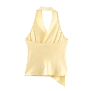 Close-up detail of a pale yellow silk satin halter neck top with asymmetric hemline