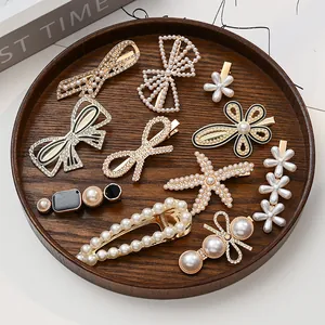 Elegant hair clip set with pearls and rhinestones on a wooden tray