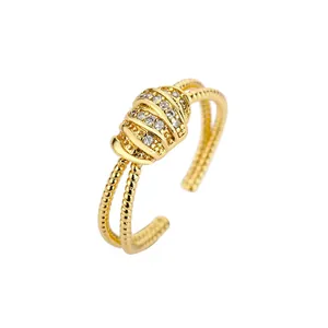 Elegante anello aperto placcato oro con micro-pavé di zirconi e texture a costine unica.