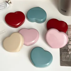 A close-up view of multiple heart-shaped contact lens cases in vibrant candy colors