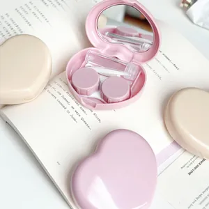 Detailed view of a pink heart-shaped contact lens case kit with travel accessories