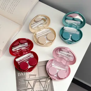 Four heart-shaped contact lens travel cases in candy colors with mirror and tools