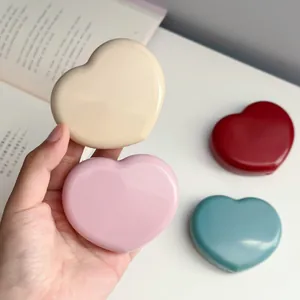 Close-up of glossy heart-shaped contact lens cases in various pastel candy colors