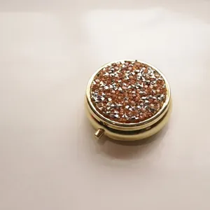 Macro view of portable round metal pillbox with a sparkling rhinestone lid detail