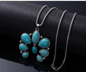 Gros plan détaillé d'un collier bohème en turquoise et sa chaîne argentée vintage