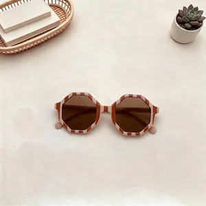 Dettaglio degli occhiali da sole ottagonali per bambini con montura a righe arancio.