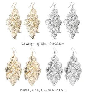 Detailed view of fashion leaf-patterned dangle earrings in gold and silver colors.