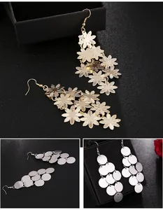 Detailed view of fashionable long tassel earrings in gold flower and silver disc styles