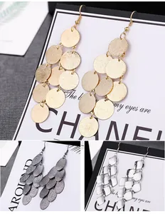 Close-up view of fashionable metallic tiered drop earrings in gold, silver, and gunmetal.