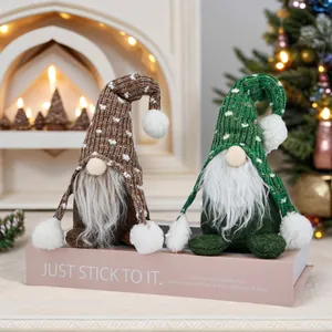 Détail de deux gnomes de Noël avec bonnets tricotés sur une boîte de livre rose décor