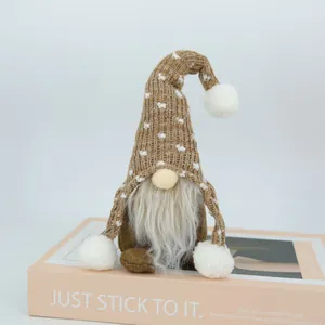 Vue détaillée d'une poupée gnome de Noël avec barbe blanche et bonnet tricoté sur un livre