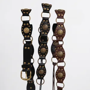 Detailed macro shot of vintage Bohemian leather waist chains with brass studs and rings.