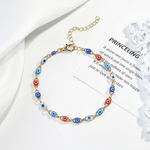 Gros plan sur un bracelet doré orné de breloques Mauvais Œil en émail multicolore éclatant