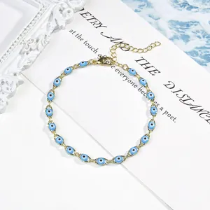 Gros plan sur les breloques mauvais œil en émail bleu sur un bracelet doré délicat
