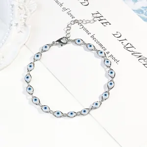 Détail en gros plan d'un élégant bracelet à breloques mauvais œil en argent et bleu