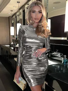 Stunning metallic silver long sleeve ruched bodycon dress shown in a luxury setting