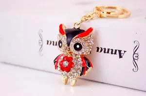 Detailed view of a cute owl keychain featuring sparkling rhinestones and red enamel