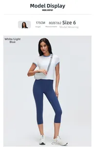 Detail view of model in white contrast sport T-shirt and navy blue yoga capri pants