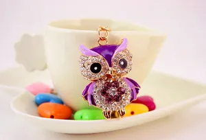 Close-up of cute purple rhinestone-encrusted owl keychain with golden finish