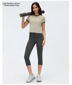 Model wearing contrast color short sleeve sports t-shirt and leggings with yoga mat