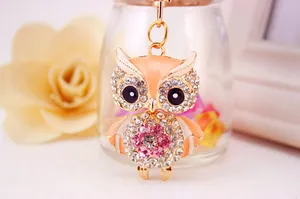 Macro detail view of a cute rhinestone-studded owl metal keychain in rose gold finish.