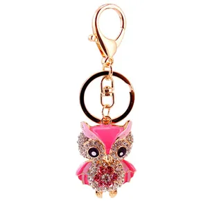 Detailed view of a cute rhinestone owl keychain with pink wings and gold metal