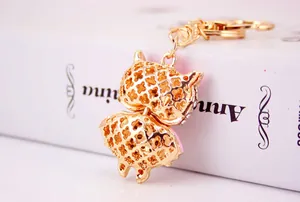 Detailed back view of a golden hollow-out owl keychain with elegant pink accents
