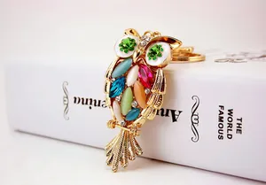 Macro detail of a cute owl keychain featuring vibrant crystals and gold-tone metal plating