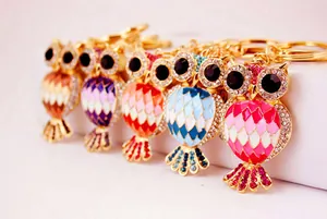 Detailed close-up showing five colorful owl keychains with rhinestones and enamel.