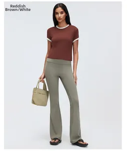 Full-length shot of a woman in a reddish-brown contrast yoga t-shirt and grey leggings