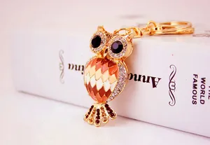 Close-up of a decorative golden rhinestone owl keychain accessory for bags and keys.