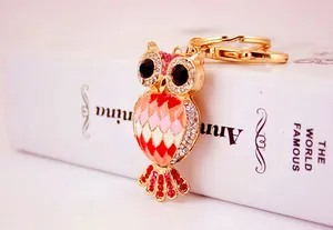 Close-up of cute owl keychain with gold finish, colorful enamel and rhinestones