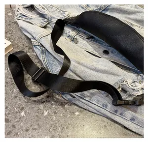 Detail view of a black punk style chest bag featuring a wide adjustable strap
