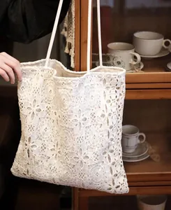 Detail shot of a white lace tote bag featuring sequin embroidery in a French style