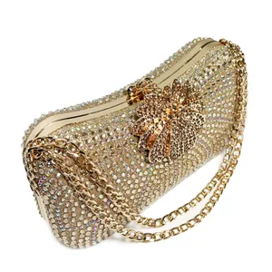 Detailed close-up of luxury gold rhinestone evening clutch with flower clasp and chain