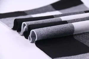 Detailed macro view of black and white checkered scarf showing soft knit fabric texture