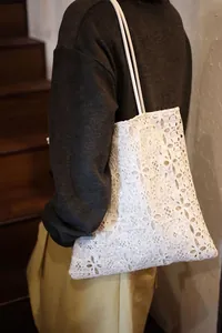 Close-up of elegant white lace and sequin texture on a stylish shoulder bag for women
