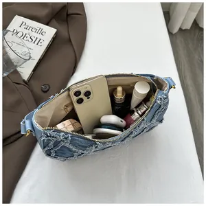 Detailed view of the large capacity interior of a distressed blue denim crescent bag
