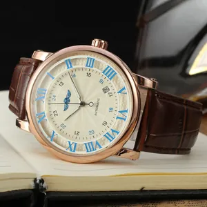 Close-up of Winner men's automatic mechanical watch with rose gold case and brown leather strap.