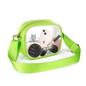 Lime green transparent PVC crossbody bag with a wide strap, showing items inside clearly
