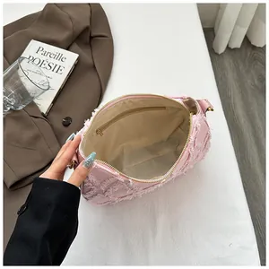 Detailed view of the pink fringe denim crescent bag showing its spacious interior lining.