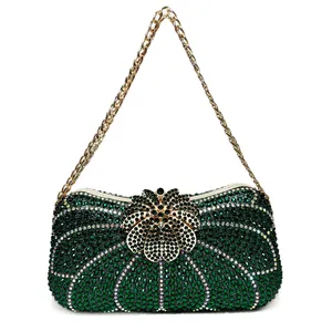 Close-up of luxury green crystal evening clutch with floral clasp and gold chain