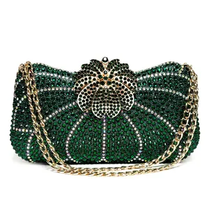 Close-up of green rhinestone evening clutch bag with golden flower-shaped metal clasp