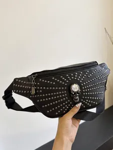 Black punk style fanny pack featuring silver rivets and a large crystal skull ornament.