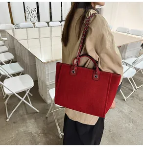 Stylish red large capacity chain tote bag shown on a model's shoulder in detail.