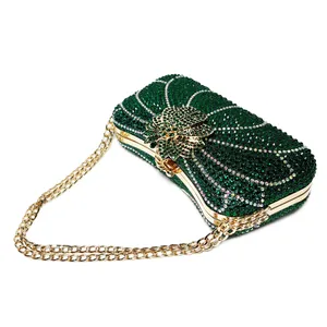 Close-up of luxury emerald green rhinestone clutch bag with gold flower clasp